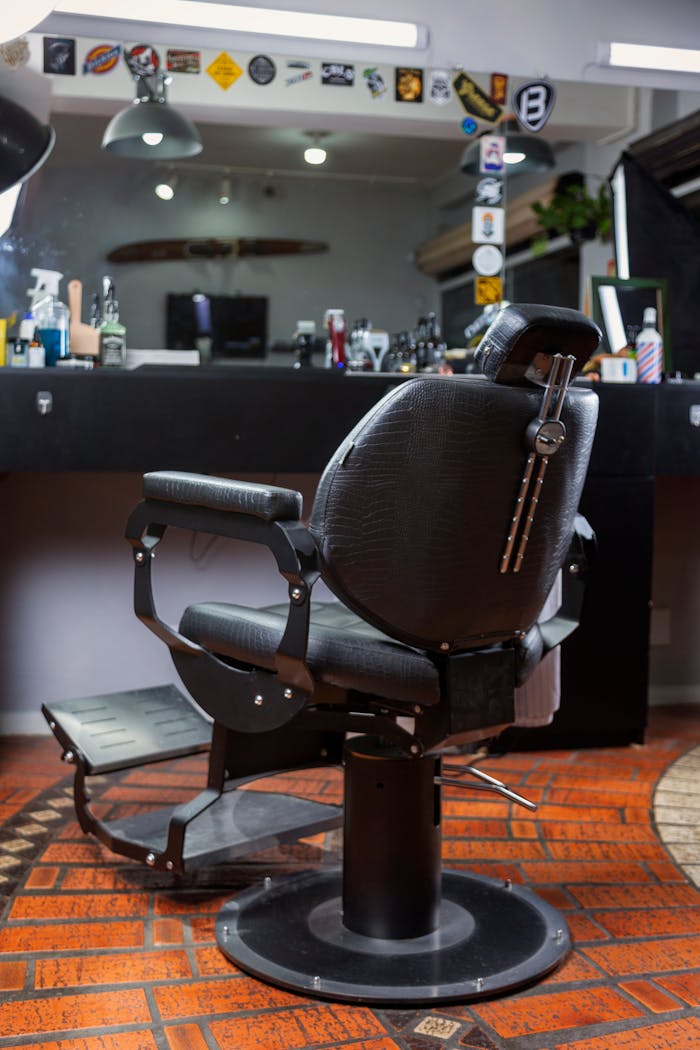 Stylish leather chair in a contemporary barbershop setting with tools and mirrors.